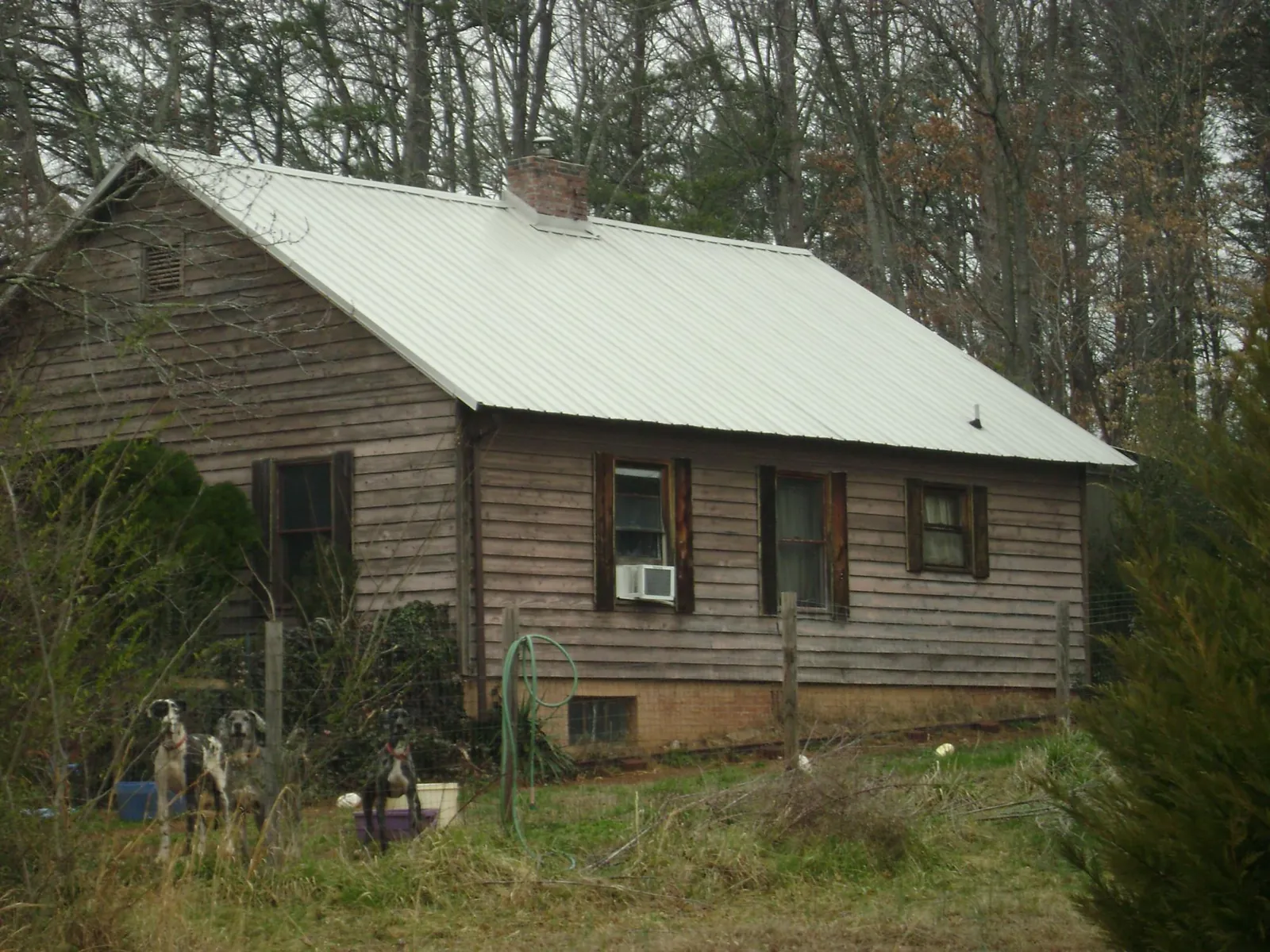 White metal roof on an old wood sided farmhouse, from a Metal Roof Installation job in Mason City